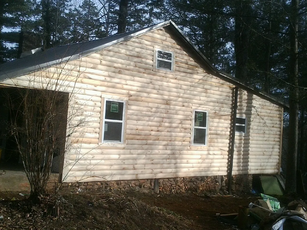 New log siding and dark metal roofing on a gable end in Lady Lake